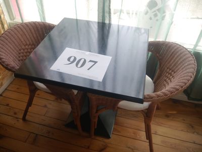 a black table with a number on it and two wicker chairs in front of a window