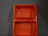 deux récipients en plastique orange posés sur une surface grise