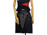 mannequin féminin vêtu d'une robe noire et rouge, posé sur un socle en bois