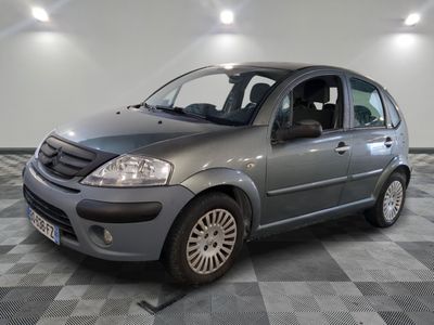 la photo d'une petite voiture grise garée dans un garage