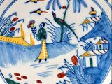 a blue and white plate with a painting on it