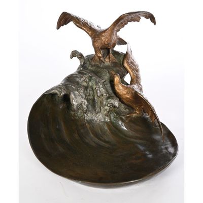 sculpture en bronze représentant deux oiseaux perchés sur un rocher au milieu de l'océan