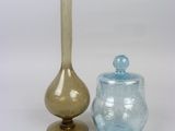 two glass vases sitting next to each other on a table
