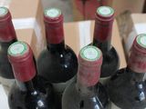 several bottles of wine sit in a cardboard box on a table