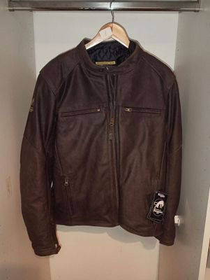 une veste en cuir marron suspendue à un cintre dans un placard
