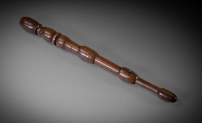 un vieux bâton en bois muni d'un manche en bois, posé sur une table