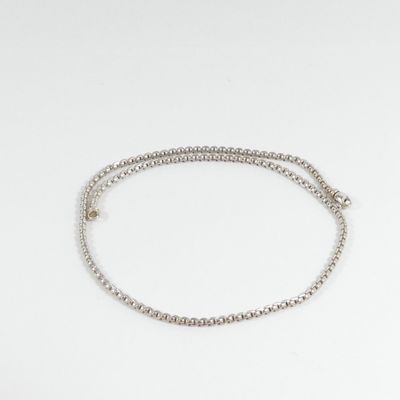 un gros plan d'un bracelet en argent muni d'une chaîne, sur fond blanc