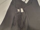 the back of a gray bag with a tag on it