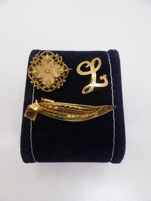 un étui en velours noir orné d'une broche en or et d'une épingle à broche