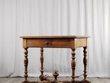 une vieille table en bois posée sur un parquet en bois dur