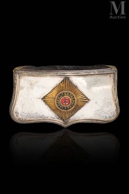 a close up of a belt buckle with a red stone in the center