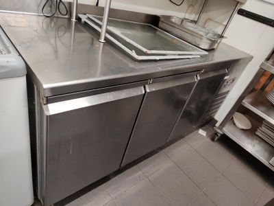 un plan de travail en acier inoxydable dans une cuisine équipée d'un lave-vaisselle