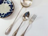 three spoons, a bowl, and a fork on a table