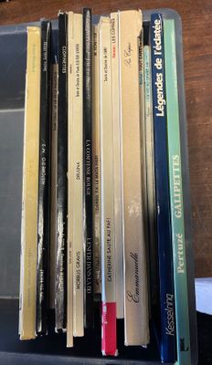 une pile de livres posée sur un bureau, à côté d'un clavier