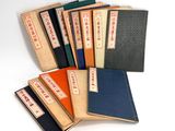 several books are stacked on top of each other on a white surface