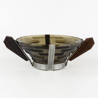 un bol en verre muni d'une poignée en bois, posé sur une surface blanche