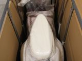 des toilettes au milieu d'un carton emballé dans du plastique