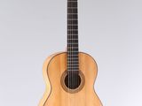 a wooden guitar sitting on top of a white surface