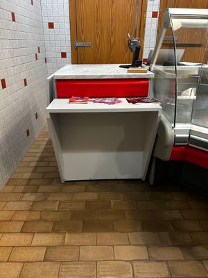 a counter with a red drawer and a white counter with a red drawer next to it