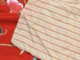 two pieces of red cloth with a pattern on them on a table