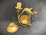 a gold plate with a bird on it and a bowl with a bird on it
