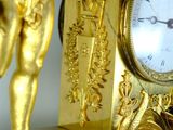 a gold clock with a statue on top of it