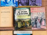 several books are sitting on a table in front of a laptop