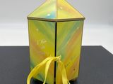 une petite boîte à laquelle est noué un ruban jaune