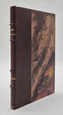 un vieux livre à la couverture marron posé sur une table blanche