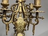 a gold colored candelier with three candles on it