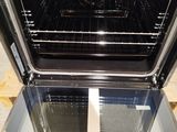 an open oven that is sitting on a wooden floor