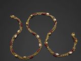 un collier en or orné de perles et de grenats sur fond noir