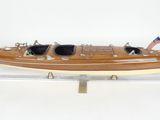 une maquette de bateau en bois sur laquelle sont posées des lunettes de soleil