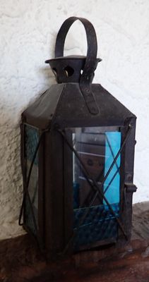 une lanterne noire contenant un verre bleu