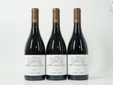 trois bouteilles de vin rouge sont posées sur une surface blanche