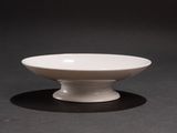 a white bowl sitting on a black surface