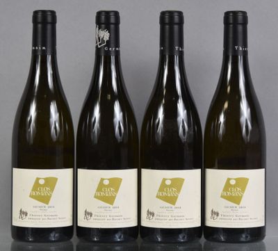 four bottles of wine are lined up on a table
