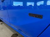 a close up of a blue car with a sticker on it