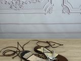 pair of brown leather sandals with laces on a wooden floor