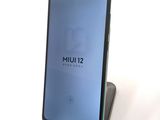 a close up of a cell phone on a stand on a white surface