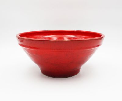a red bowl that is sitting on a white surface