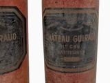 pair of old wine bottles with labels on them on a white background