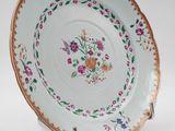 a close up of a plate with flowers on it on a stand