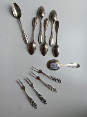 several spoons, forks, and spoon spoons are laid out on a table