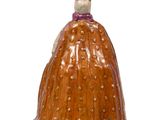 a ceramic figurine of a woman wearing a dress