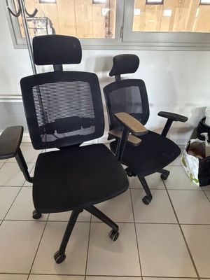 une chaise de bureau noire et une chaise de bureau noire dans une pièce