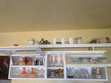 many glasses and vases on the shelves in the kitchen