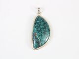 a pendant with a green stone in the middle