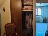 une armoire remplie de vêtements et une chaise dans un coin de la pièce
