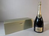 une bouteille de champagne à côté d'un coffret sur une table